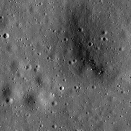 A cratered lunar plain in a soft grey orbital image at 1.1 metres per pixel, small craters blurred to dark smudges