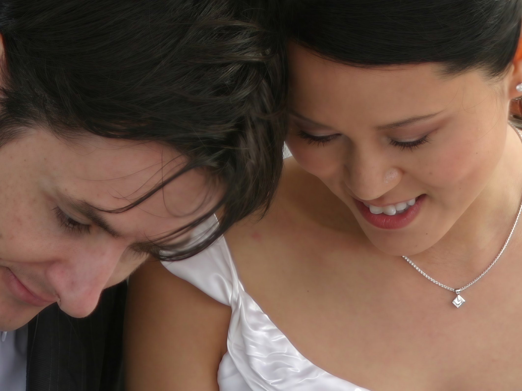 The same crop from the photograph enlarged to 9,000 pixels wide, the strands of their hair, her eyelashes, his stubble and her pendant drawn sharply